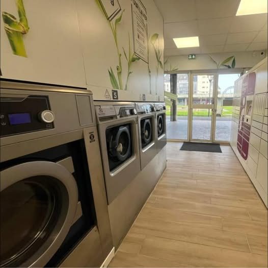 Rangée de lave-linges en libre-service chez Point Laverie